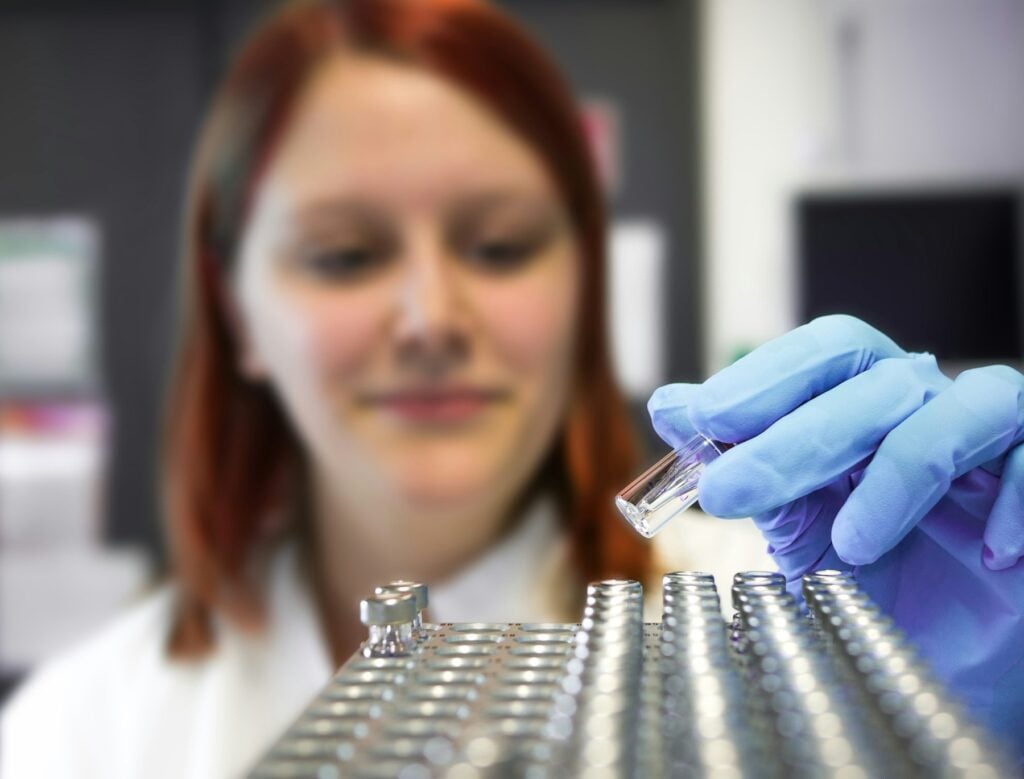 Laboratoriespecialist på Deus Medical granskar en injektionsflaska